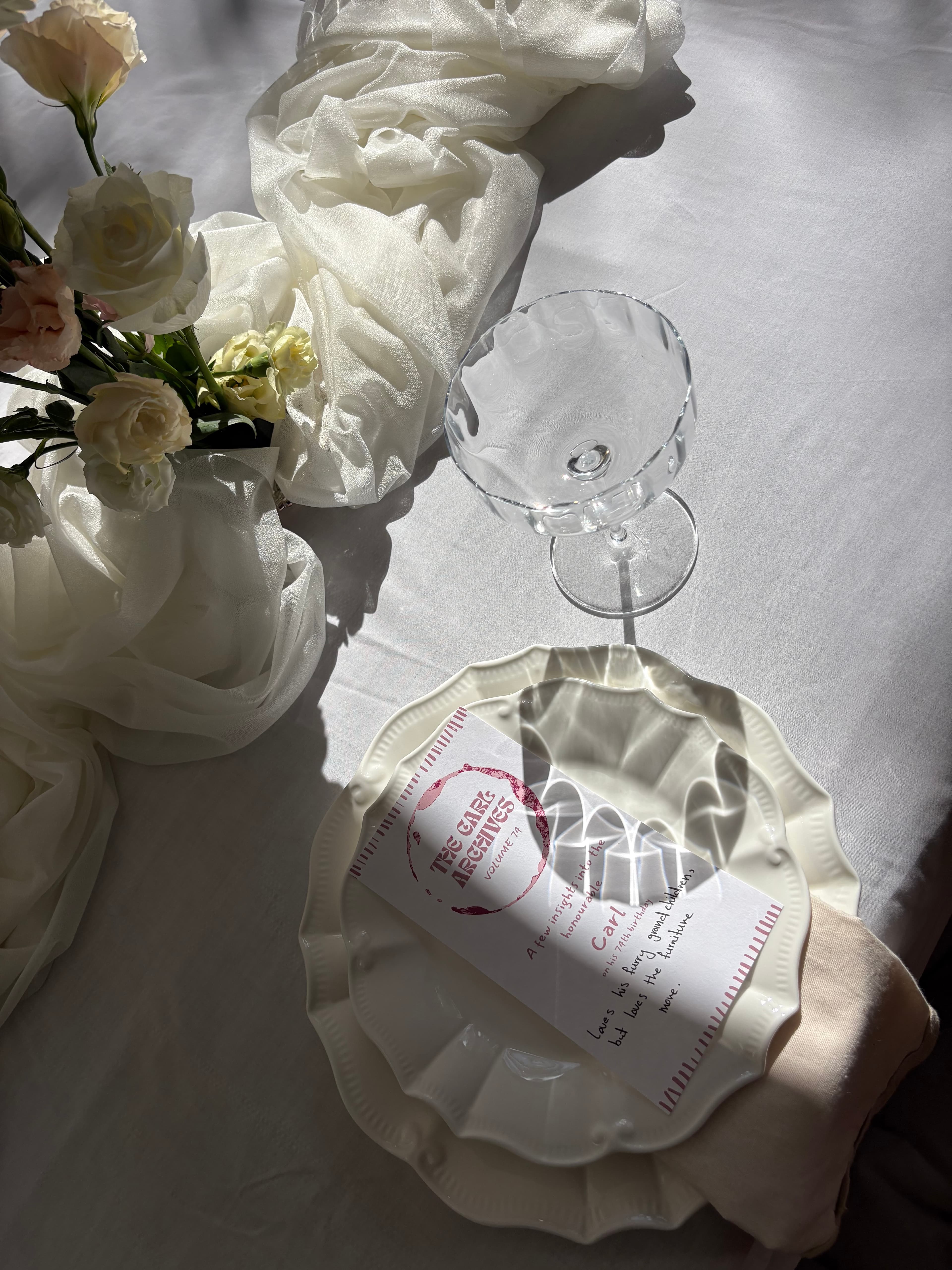 Outdoor wedding dessert table styling with florals, fruit, and soft draping